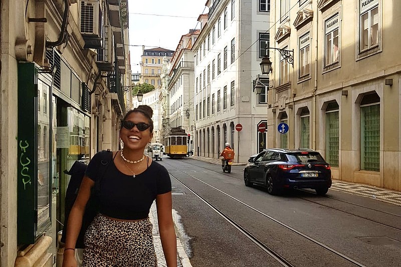 Sali in einer typischen Straße in Lissabon. Im Hintergrund ist eine Straßenbahn.
